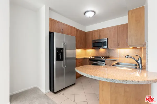 a kitchen with granite countertop a refrigerator and a sink