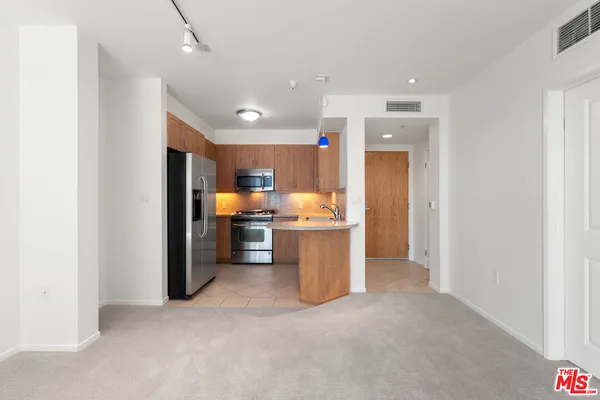 a view of a kitchen with a refrigerator and a sink