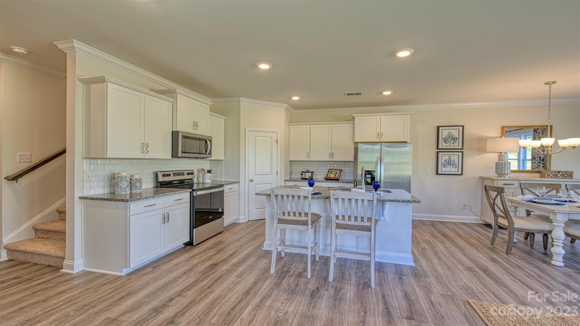 41 Ravens Rdg Road Hendersonville, NC 28792 - Photo 8 of 41 a kitchen with microwave a stove top oven a sink dishwasher a dining table and chairs with wooden floor