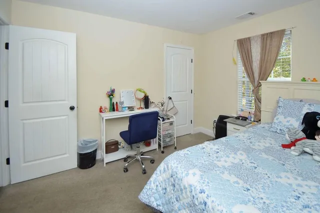 a bedroom with a bed a desk and chair