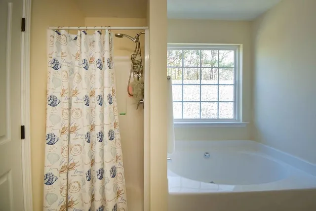 a white bath tub sitting next to a shower
