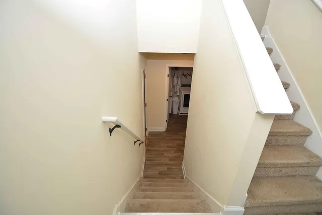 a view of a hallway with wooden floor and staircase