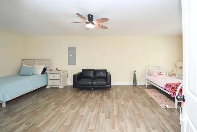 a living room with a bed furniture and a wooden floor