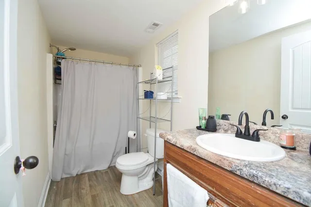 a bathroom with a granite countertop sink toilet and shower