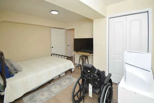 a bedroom with a bed window and a flat screen tv