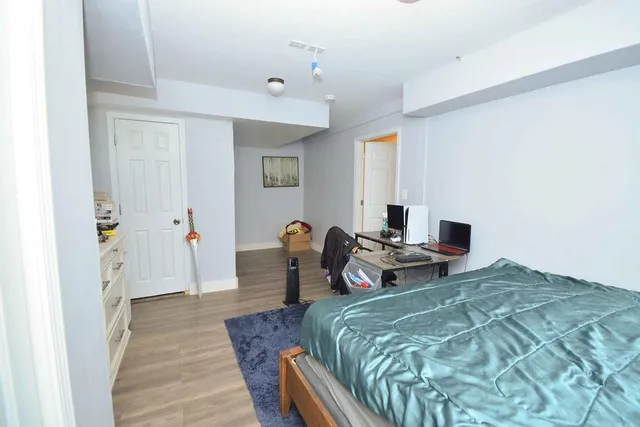 a bedroom with a bed and a wooden floor