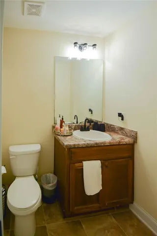 a bathroom with a granite countertop toilet and a sink