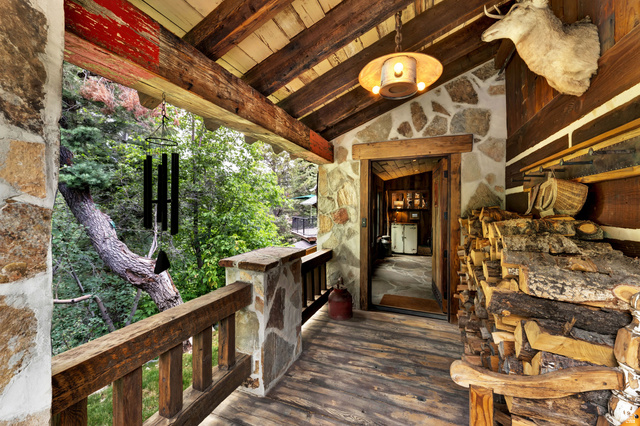 2983 East Ridgetop Road, Unit 27 Provo, UT 84604 - Photo 3 of 63 Rustic covered porch featuring exposed wood beam ceiling, wood-finish flooring, and natural stone exterior walls