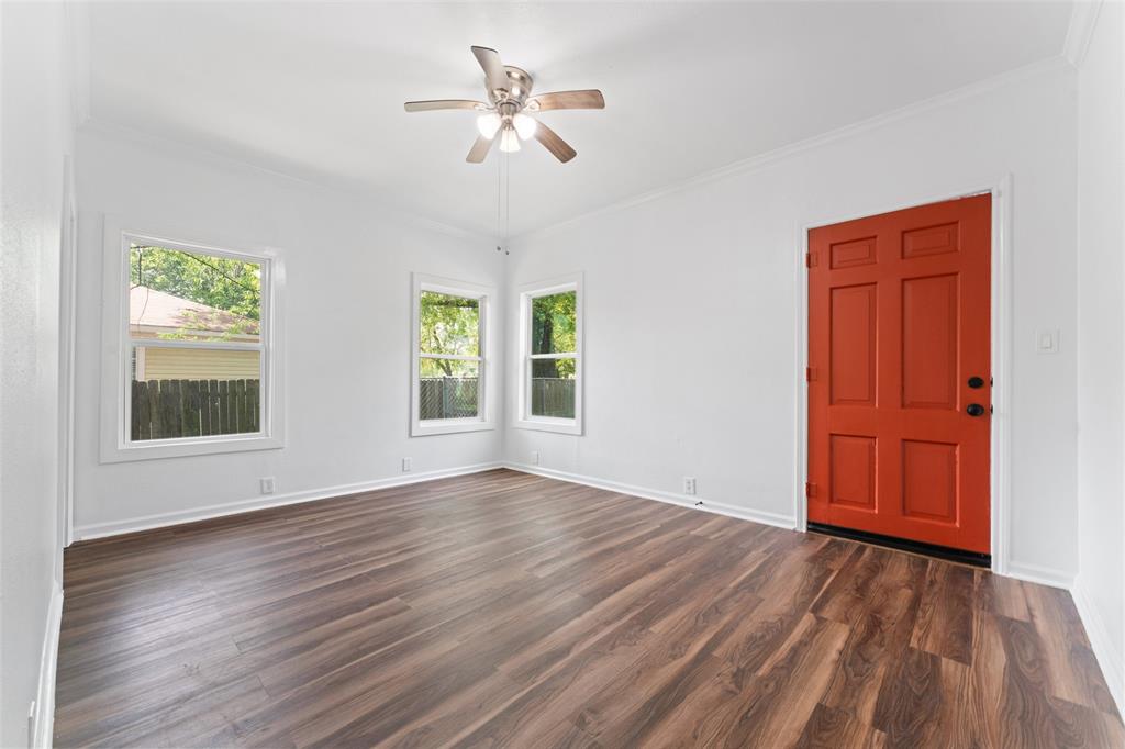 2405 Monroe Street Commerce, TX 75428 - Photo 21 of 31 an empty room with wooden floor chandelier fan and windows