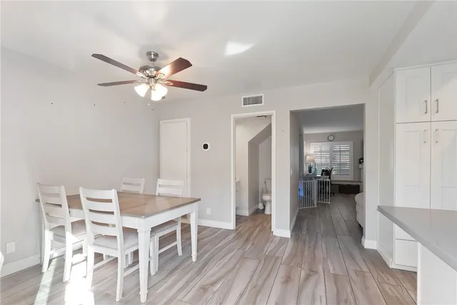a view of a livingroom with furniture wooden floor and a ceiling fan