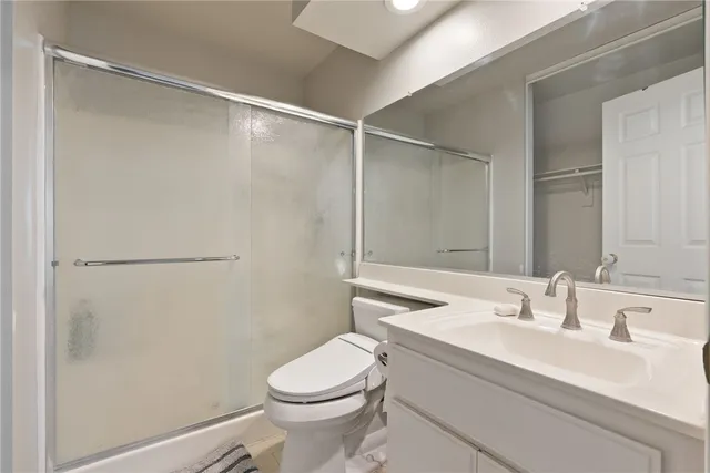 a bathroom with a sink mirror vanity and toilet