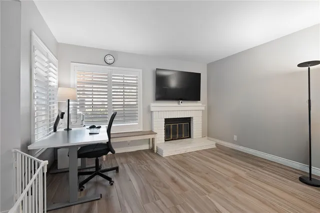 a work room with furniture a flat screen tv and a fireplace
