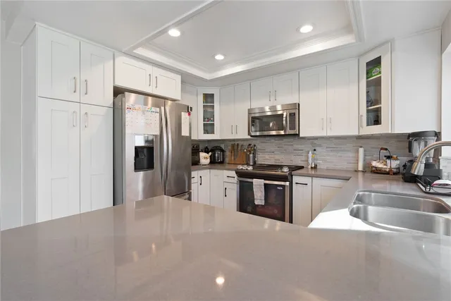 a kitchen with stainless steel appliances granite countertop a refrigerator stove microwave and sink
