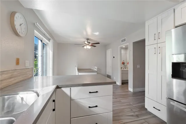 a kitchen with stainless steel appliances granite countertop a refrigerator a oven and a sink with large window