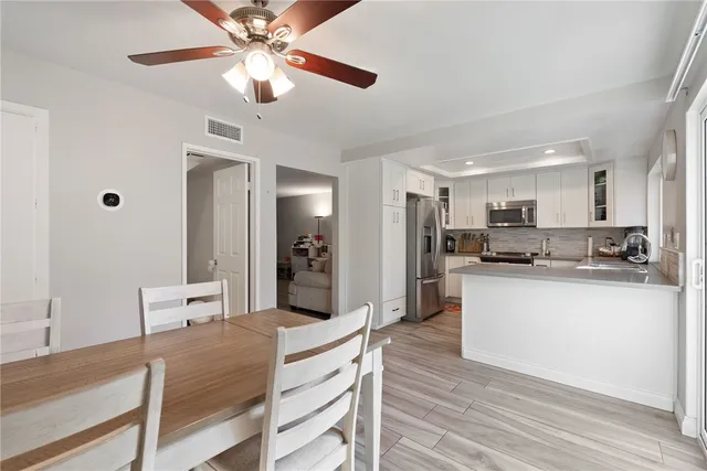 a kitchen with stainless steel appliances kitchen island granite countertop a refrigerator a stove top oven a sink with island and chairs