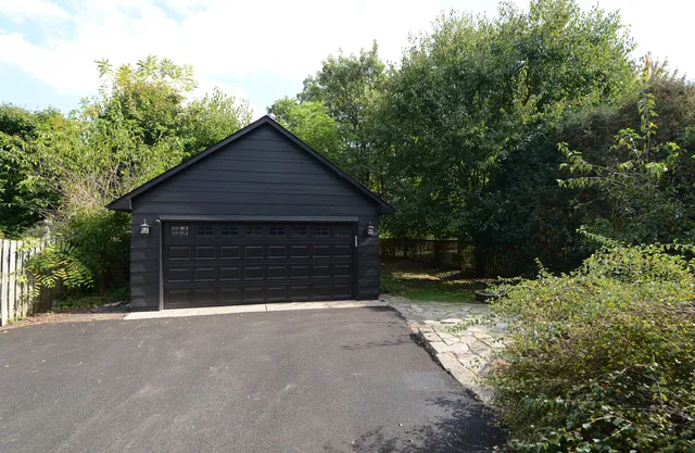 a view of a house with a small yard and garage