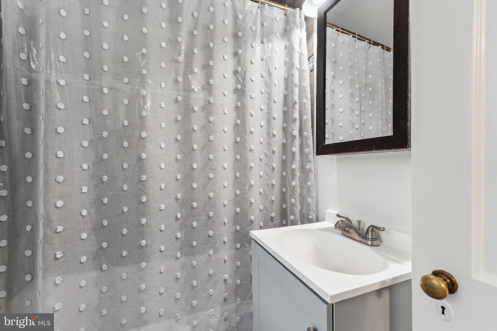 9222 Glenville Road Silver Spring, MD 20901 - Photo 11 of 15 a bathroom with a sink a toilet and mirror