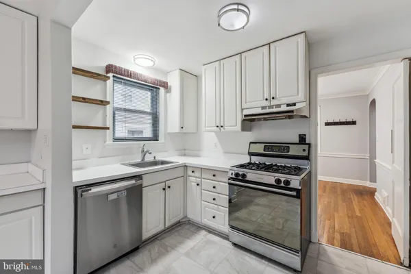 a kitchen with granite countertop a sink cabinets and stainless steel appliances