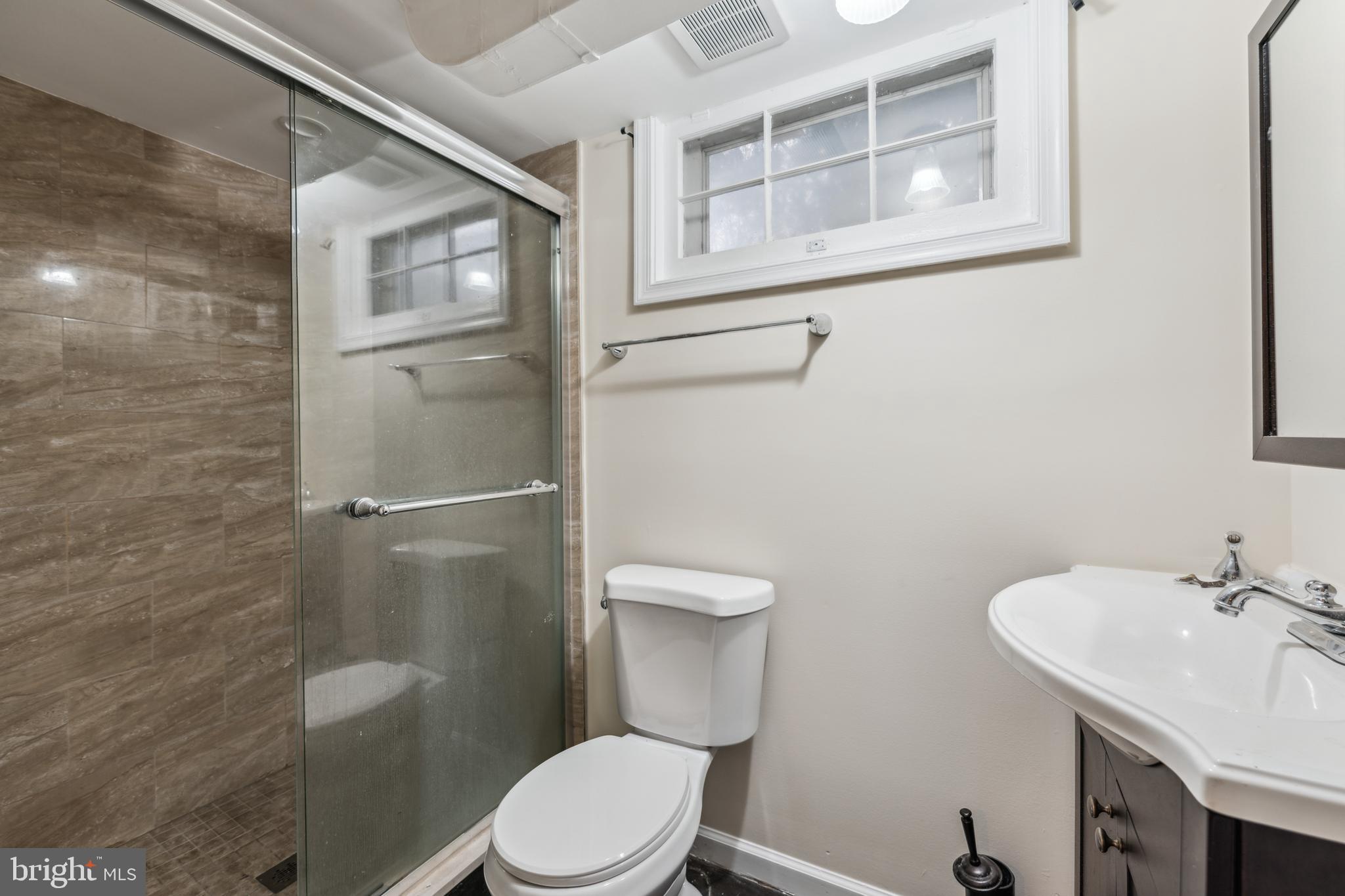 9222 Glenville Road Silver Spring, MD 20901 - Photo 10 of 15 a white toilet sitting next to a bathroom sink