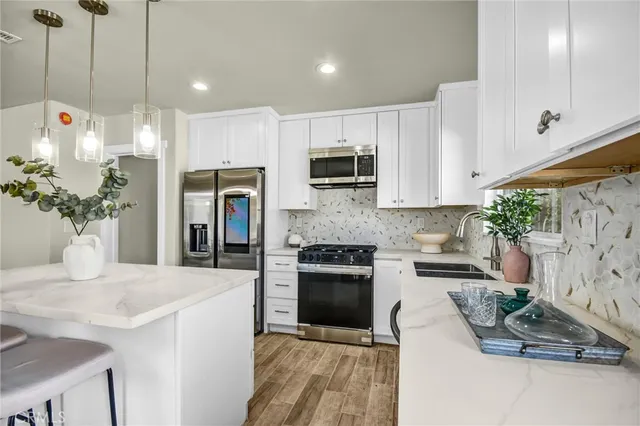 a kitchen with stainless steel appliances kitchen island granite countertop a stove a sink and a microwave