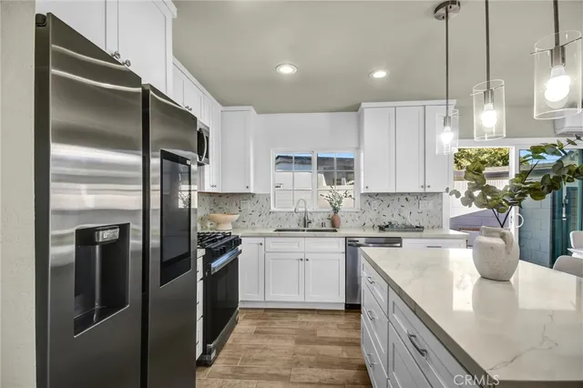 a kitchen with a sink stainless steel appliances and white cabinets