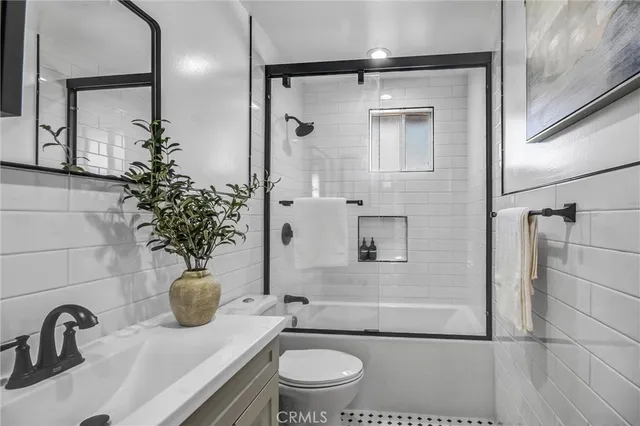 a bathroom with a granite countertop sink a toilet and shower