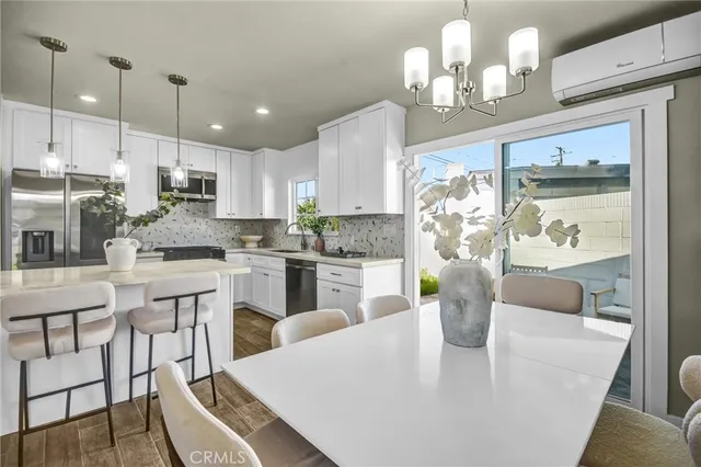 a kitchen with stainless steel appliances granite countertop a stove a kitchen island a dining table and chairs