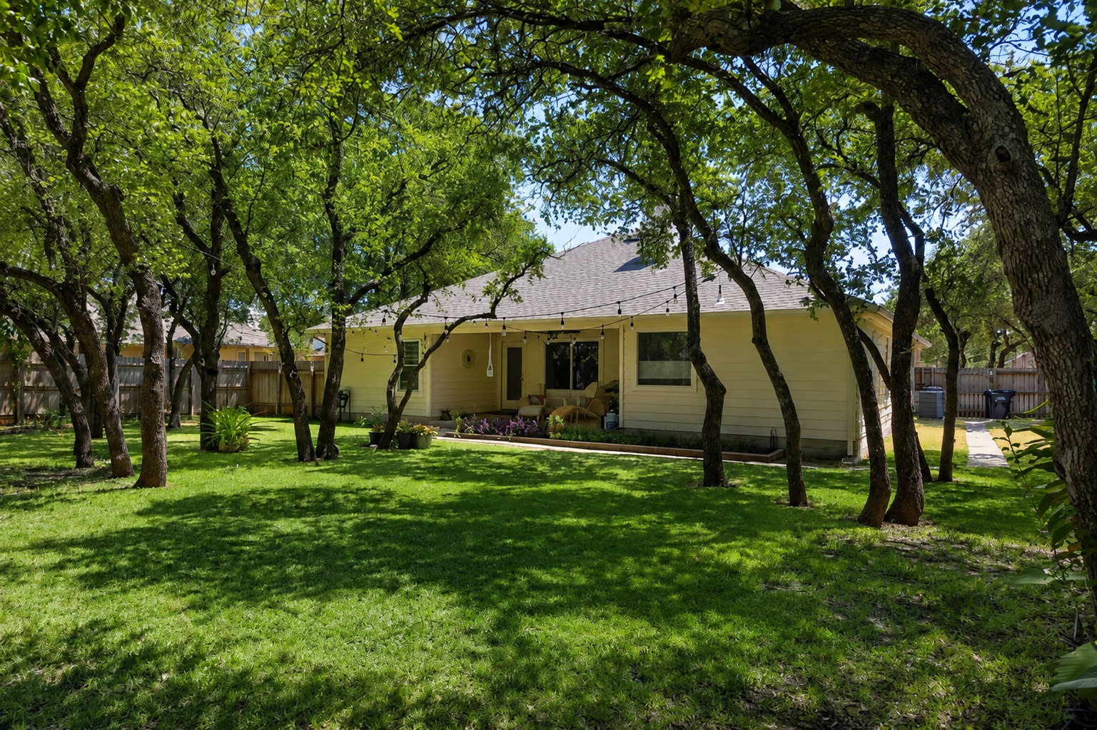 1921 Rutherford Drive Leander, TX 78641 - Photo 26 of 29 Mature trees shade a spacious green lawn behind the single-story residence. Virtually Enhanced.