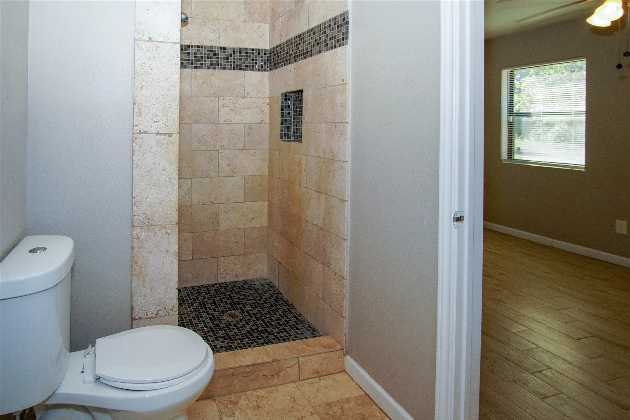 1926 16th Street Hempstead, TX 77445 - Photo 13 of 19 a bathroom with a toilet a window and shower