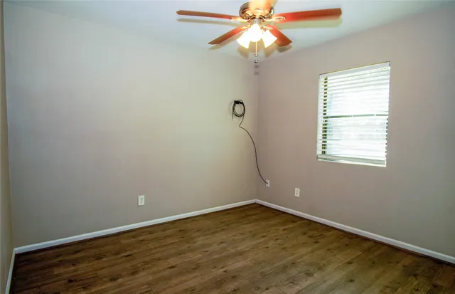 an empty room with a window and wooden floor