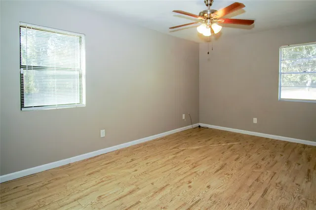 an empty room with a window and a fan
