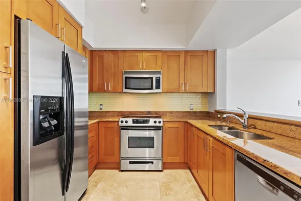 a kitchen with stainless steel appliances granite countertop a stove a sink and a microwave
