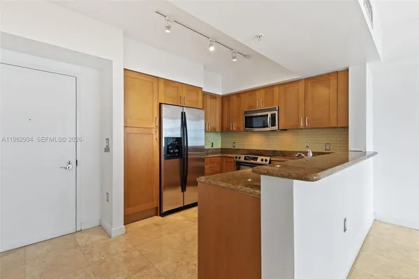 a kitchen with stainless steel appliances granite countertop a refrigerator stove and oven