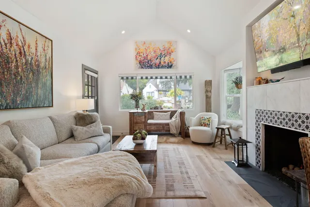 a living room with furniture large window and a fireplace