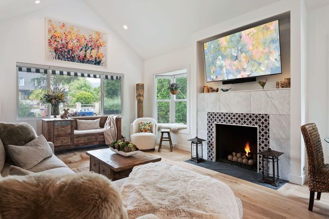 a living room with furniture a fireplace and a large window