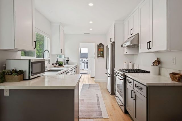 a kitchen with stainless steel appliances a sink stove and cabinets