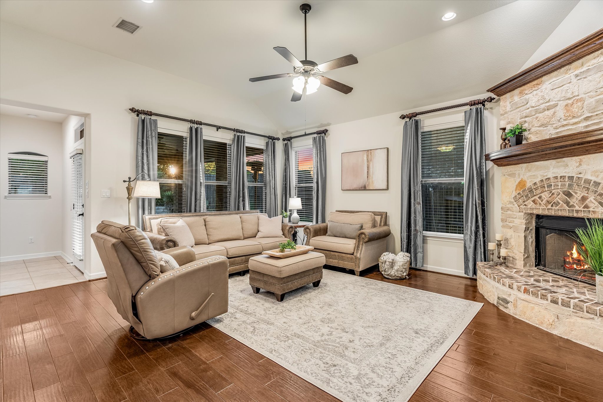 226 Galloway Lane Austin, TX 78737 - Photo 8 of 30 Living area featuring vaulted ceiling, a stone fireplace, dark wood-style flooring, ceiling fan, and recessed lighting