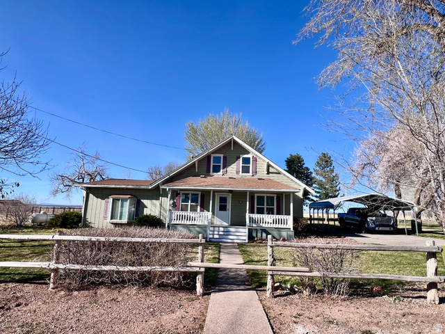 479 East 100 N Road Meadow, UT 84644 - Photo 46 of 59 Bungalow-style house featuring a porch, a detached carport, a fenced front yard, and roof with shingles