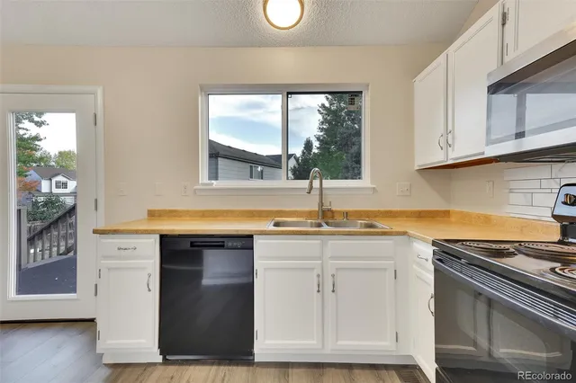 a kitchen with stainless steel appliances granite countertop a sink stove and cabinets