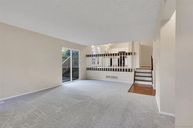 a view of a livingroom with a white wall and stairs