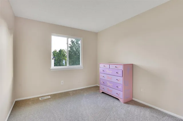 an empty room with windows and cabinet