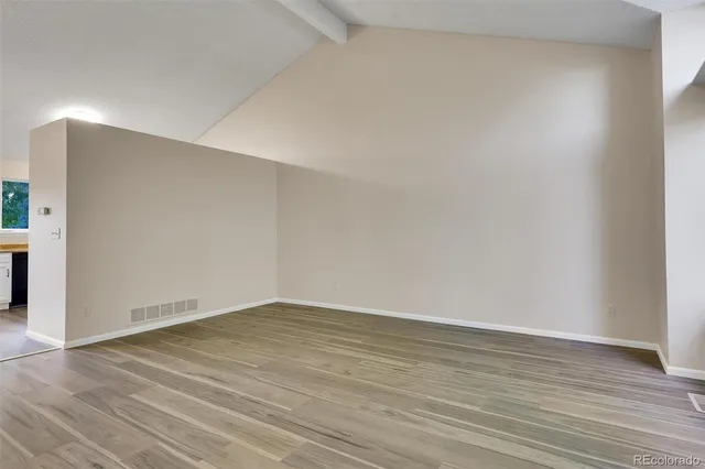 a view of an empty room with wooden floor