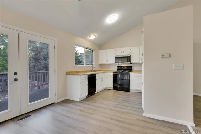 a kitchen with granite countertop a refrigerator and a stove top oven