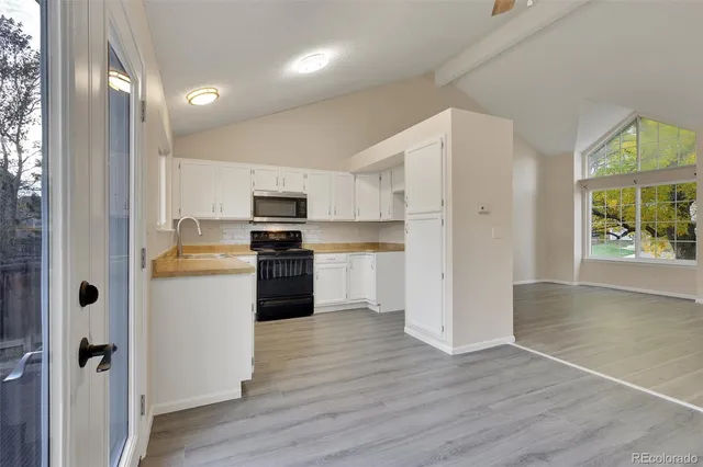 a kitchen with a refrigerator a stove top oven a sink and a window