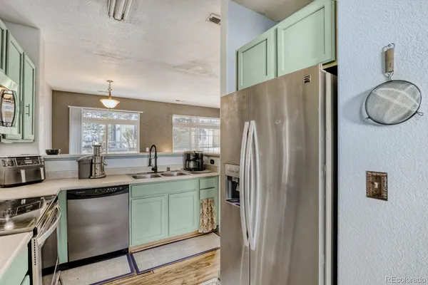 a kitchen with stainless steel appliances granite countertop a refrigerator and a stove top oven
