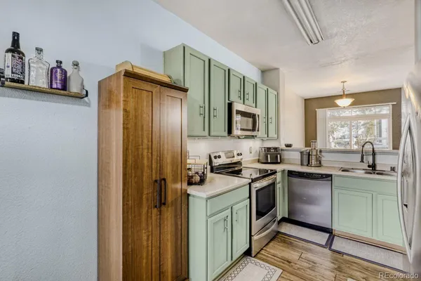 a kitchen with stainless steel appliances granite countertop a stove a sink and a refrigerator