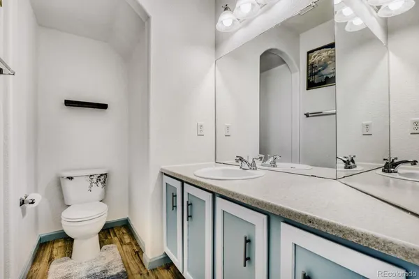 a bathroom with a granite countertop sink a toilet and mirror