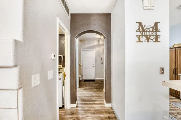 a view of a hallway with wooden floor and a dining room