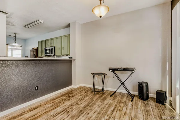 a view of a room with wooden floor and electronic appliances