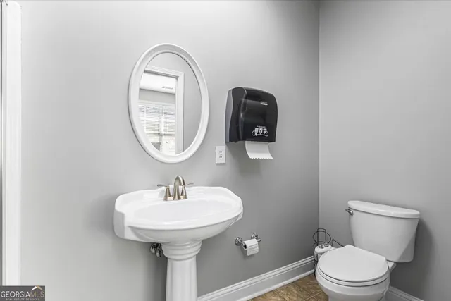 a bathroom with a toilet sink and mirror